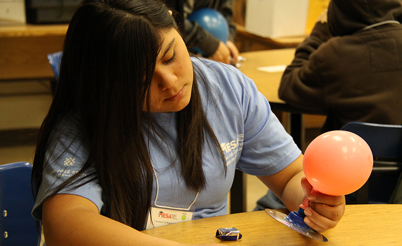 Girl in MESA shirt plays with balloon experiment